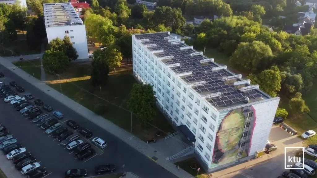 Ant universiteto pastatų stogų matomos saulės baterijos.