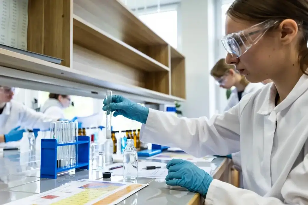 Mokslininkė dirbanti su tyrimų mėgintuvėliais ir atspindinti mokslo pasiekimus Lietuvoje.