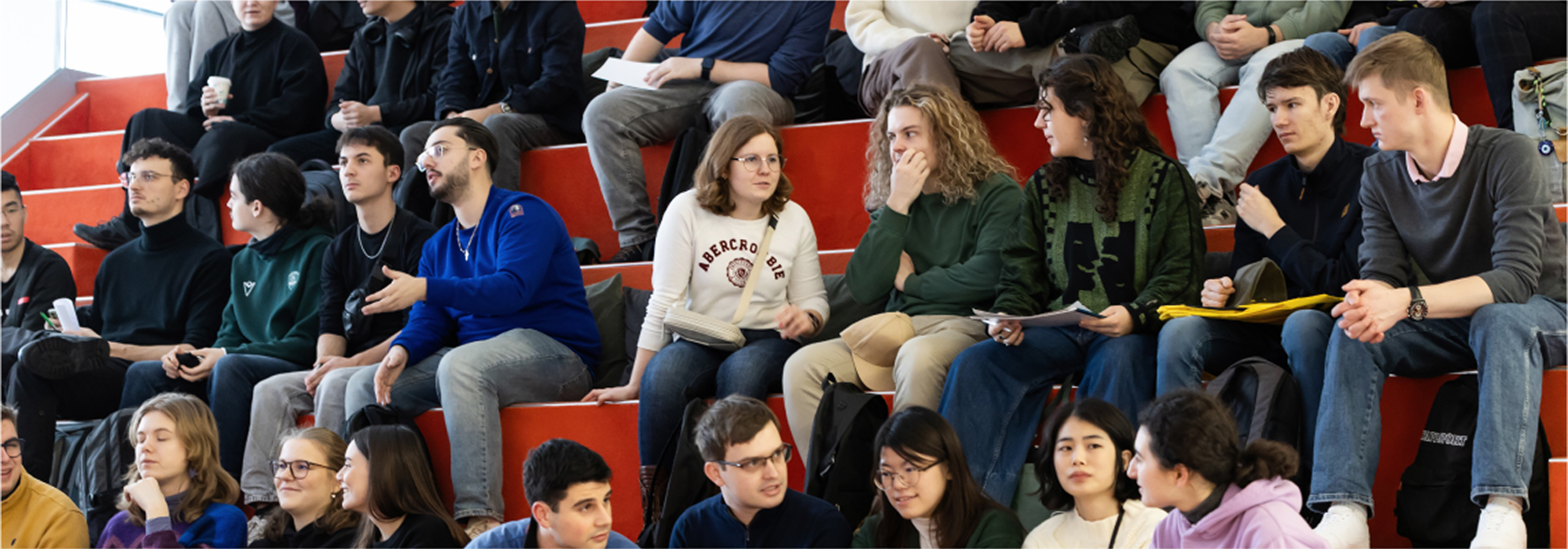 Baneris – Įtrauki ir kūrybinga bendruomenė KTU strateginės krypties „Įtrauki ir kūrybinga bendruomenė“ vizualas. Universiteto amfiteatre susirinkę studentai bendrauja ir dalyvauja renginyje. Vizualas atspindi aktyvią akademinę bendruomenę, įsitraukimą, bendradarbiavimą ir idėjų mainus.