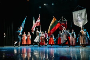 Meno kolektyvo nariai, kartu su kitais &scaron;okėjais i&scaron; Latvijos ir Estijos, stovi ant scenos laikydami savo &scaron;alių valstybines vėliavas