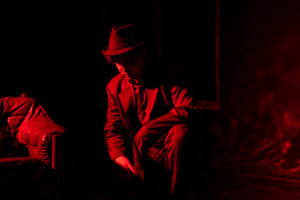 KTU teatro studija „44“ Teatro studijos narys priklauspęs ant vieno kelio raudonoje šviesoje