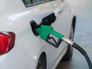 Į automobilio baką įstatytas degalų pistoletas degalinėje