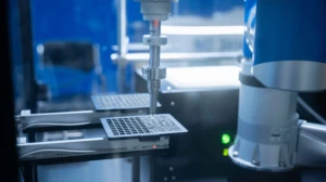Laboratorijoje veikiantis robotas automatiškai apdoroja mėginių plokštelę
